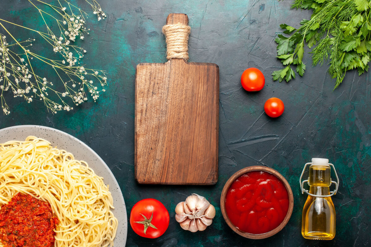 油在深蓝色的桌子上 俯瞰着用碎番茄肉和油做成的意大利面食午餐晚餐顶部