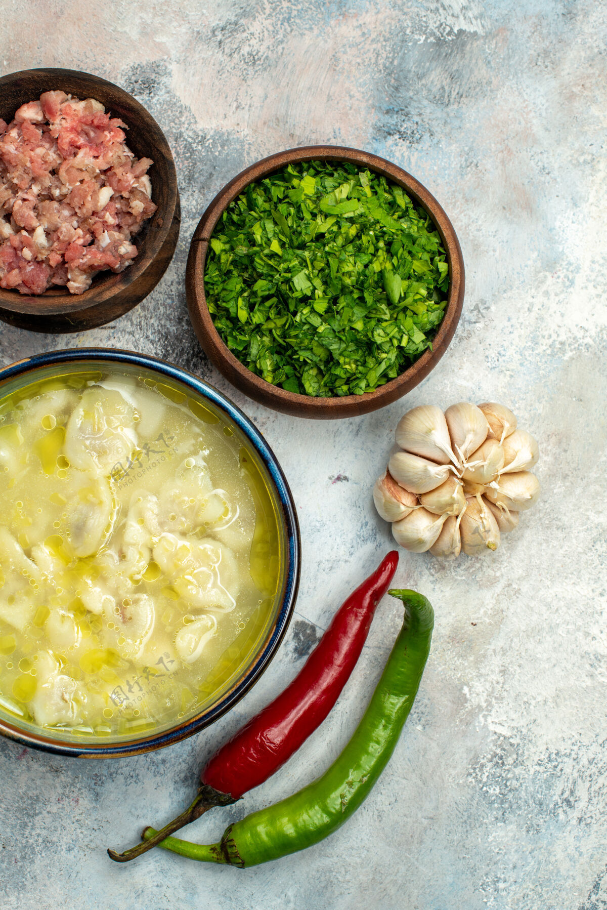 晚餐俯瞰杜什巴拉饺子汤碗大蒜辣椒碗肉和绿色裸体表面胡椒菜顶部