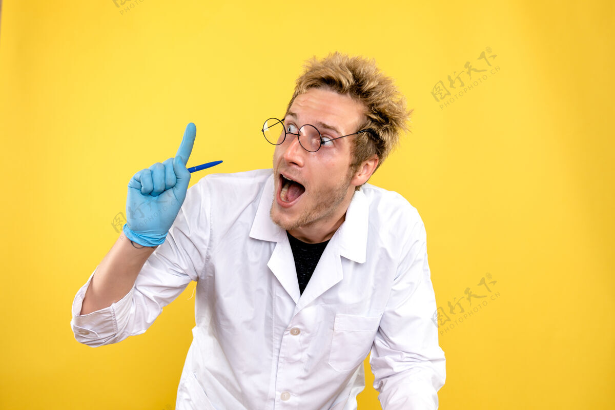 帅哥正面图黄色背景上带笔的男医生医学博士-健康人肖像冠状病毒男性