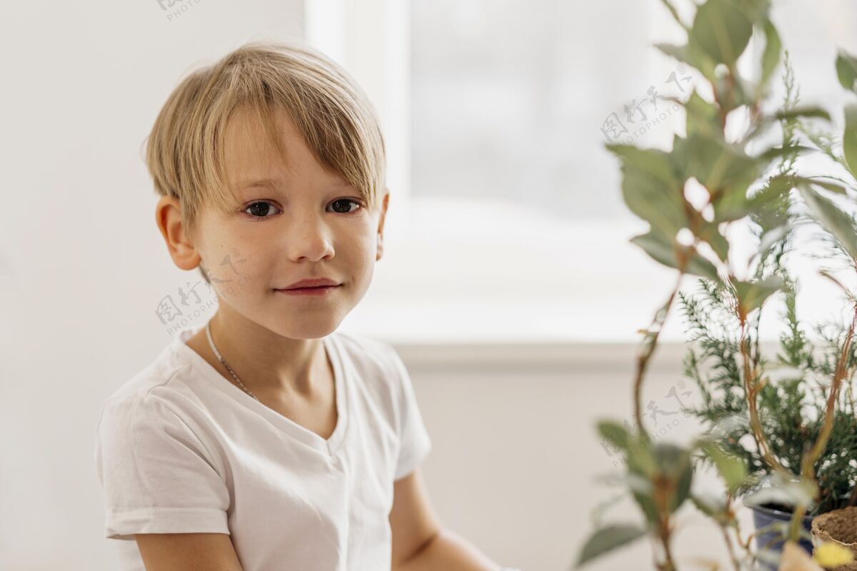 园艺可爱的孩子坐在家里的植物旁边树木栽培农业栽培