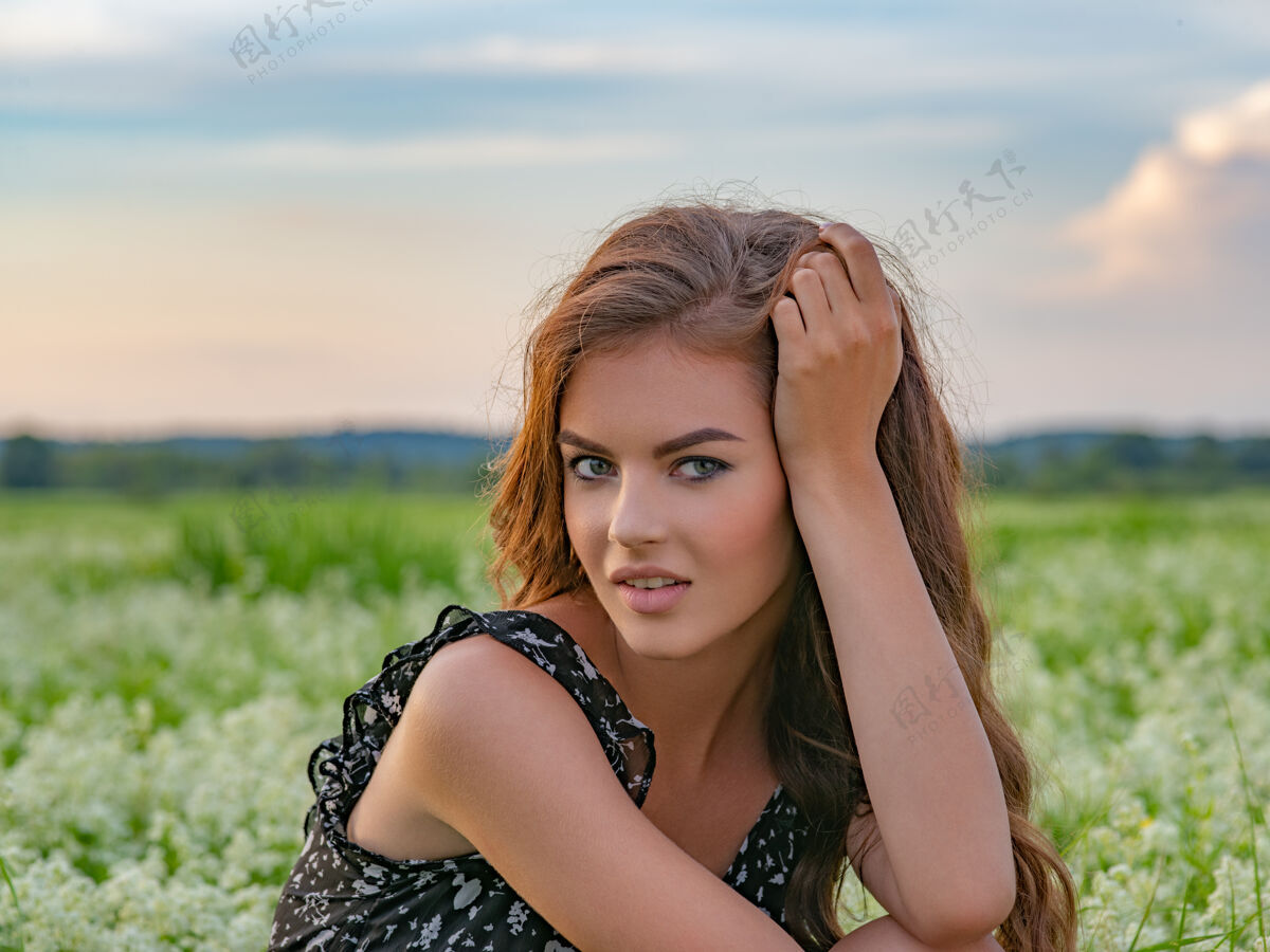 休闲在一片白色薰衣草花丛中摆姿势的女人坐在户外一片白色花丛中的年轻成年女孩的画像女孩女性漂亮