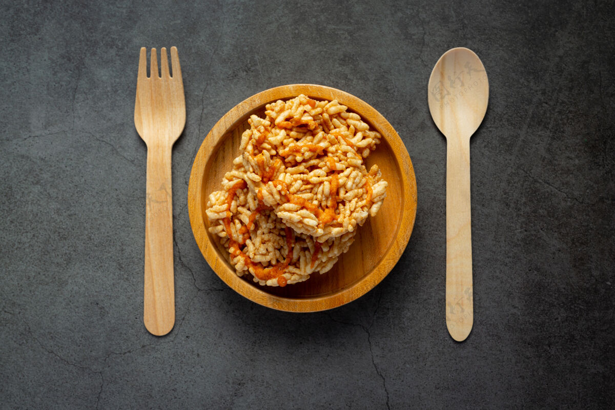 小麦泰国小吃；用木勺和叉子盛在木碗里的花坛或米糕谷物必需餐饮