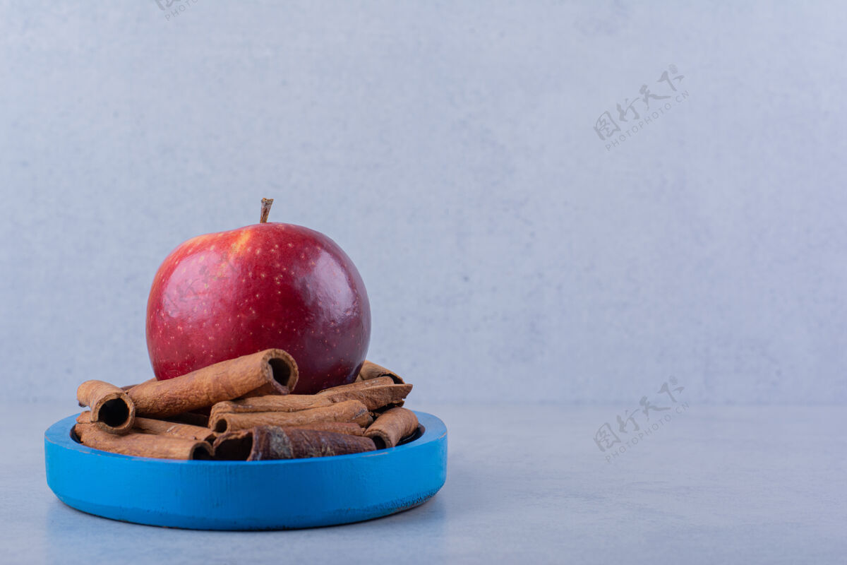 芳香蓝色的盘子里放满了肉桂和苹果水果健康新鲜
