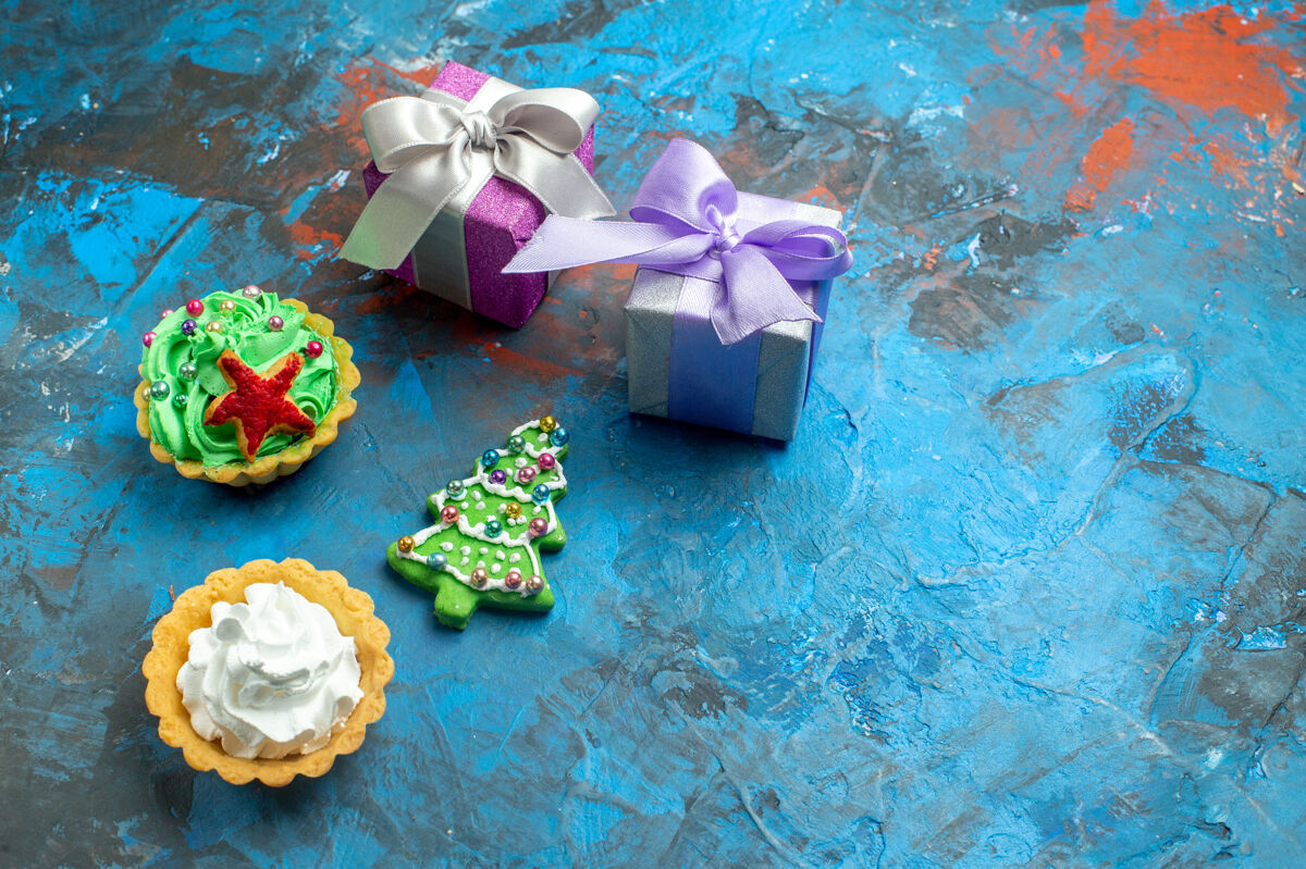 地方顶视图小馅饼小礼物圣诞树饼干蓝红色桌子上的复制地方庆祝圣诞装饰