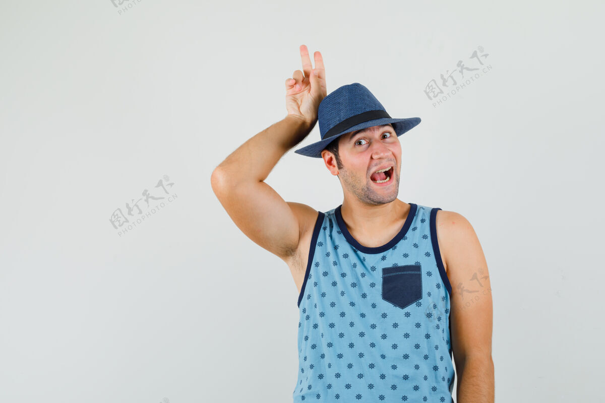 Vsign穿蓝色单品的年轻人 戴着帽子 头后举着v字标志 看上去很滑稽成功控股胡须