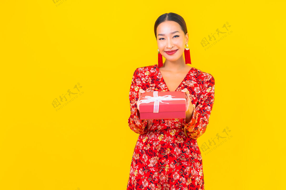 日本人美丽的亚洲年轻女子肖像 彩色墙上有红色礼盒人人喜悦