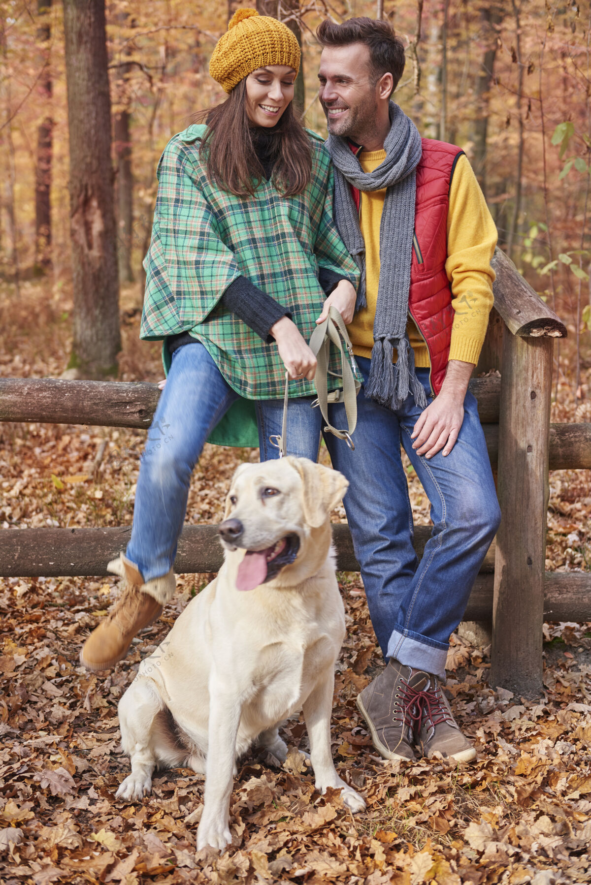 微笑夫妻俩在森林里和狗在一起户外护理时尚