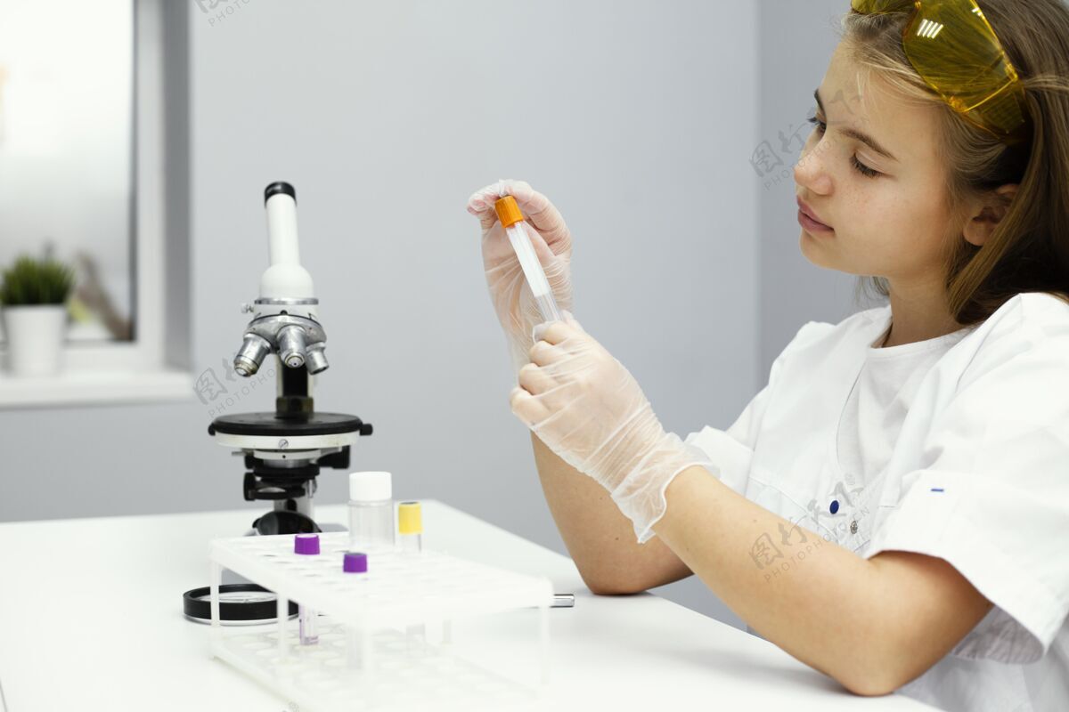安全眼镜戴着安全眼镜和显微镜的女科学家侧视图实验室外套青年实验室