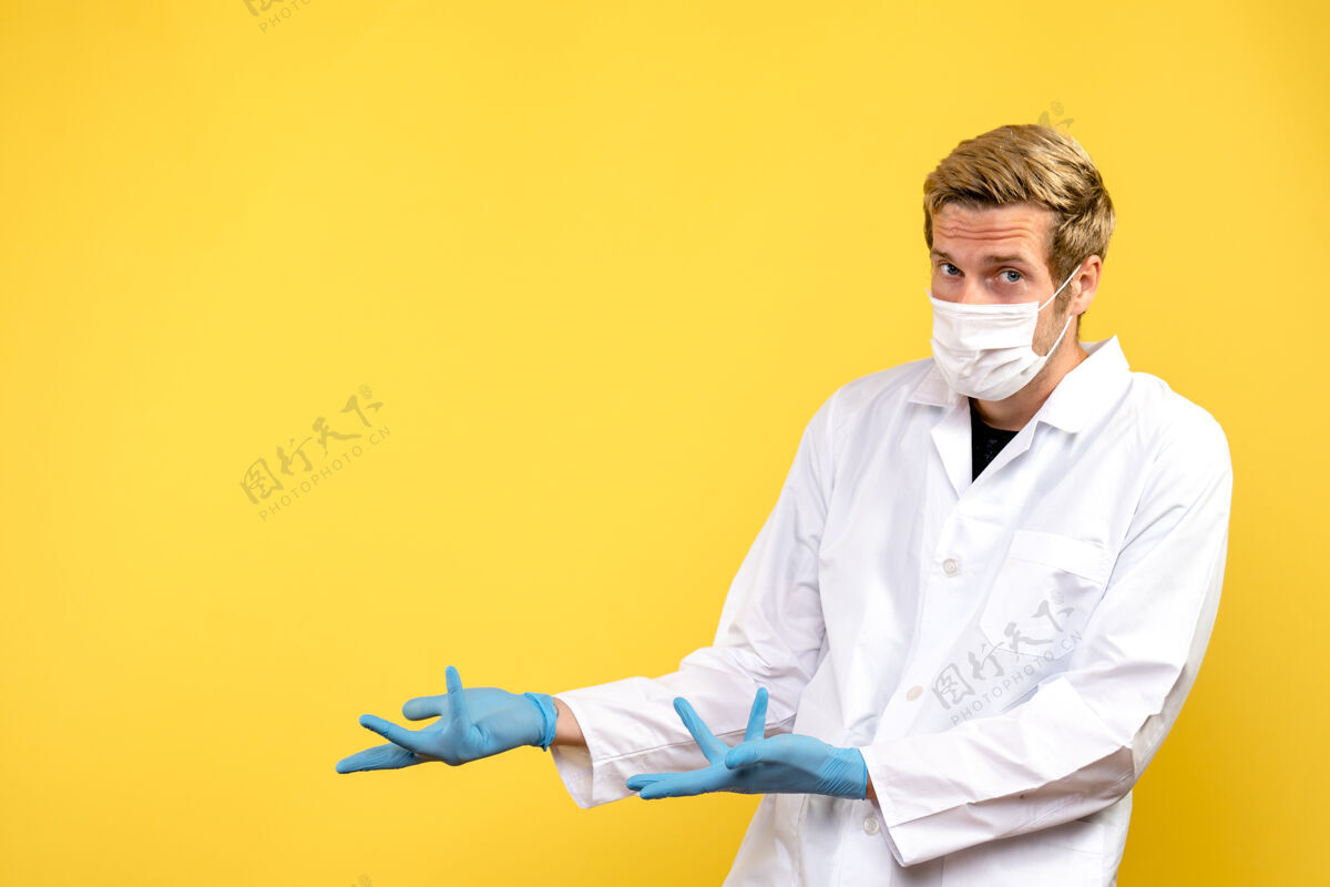 视图正面图黄色桌子上的男医生健康病毒大流行病毒办公桌工作外观