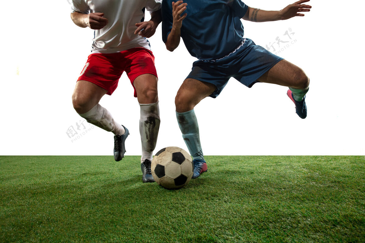 运动员格斗职业足球的特写腿 足球运动员在隔离在白墙上的场地上为球而战动作 动作的概念 比赛中高度紧张的情绪裁剪的图像动作足球球