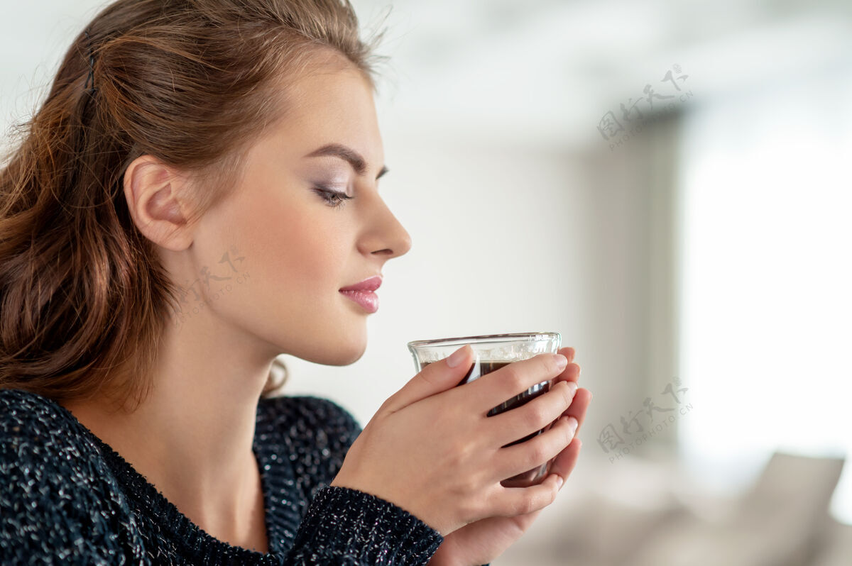 享受美丽的女人喝着咖啡 享受着咖啡的味道年轻漂亮的女孩喝着茶 放松着杯子人看