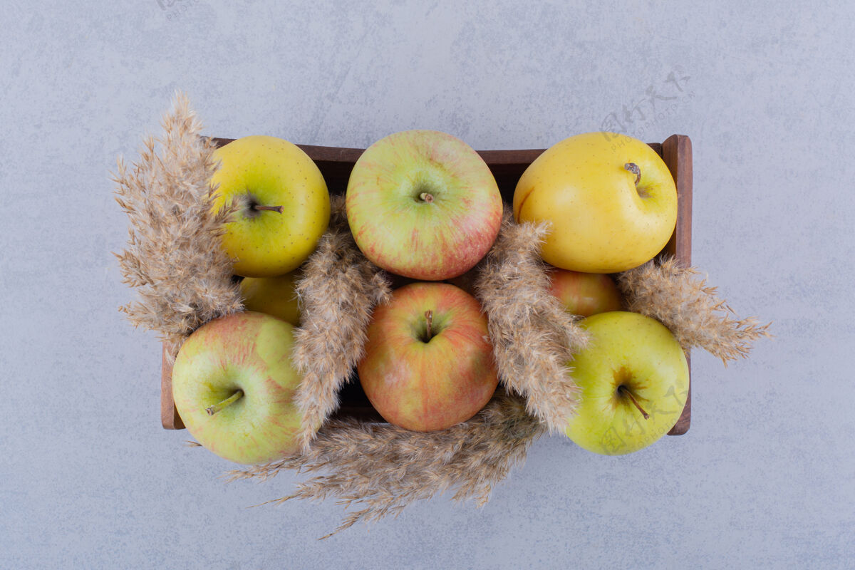 有机石头桌上放着一盒新鲜的青苹果水果成熟苹果