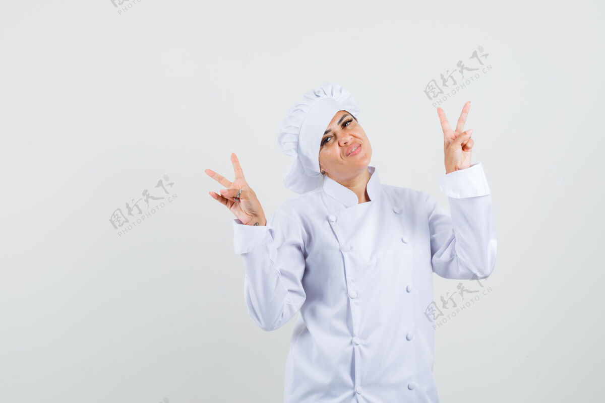 举行女厨师穿着白色制服展示v字标志 看上去很欢快表演专业食品