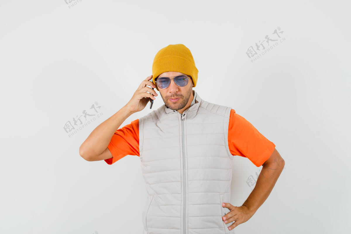 休闲一个穿着t恤衫 夹克衫 帽子 面带沉思的年轻人在讲手机发型T恤商人