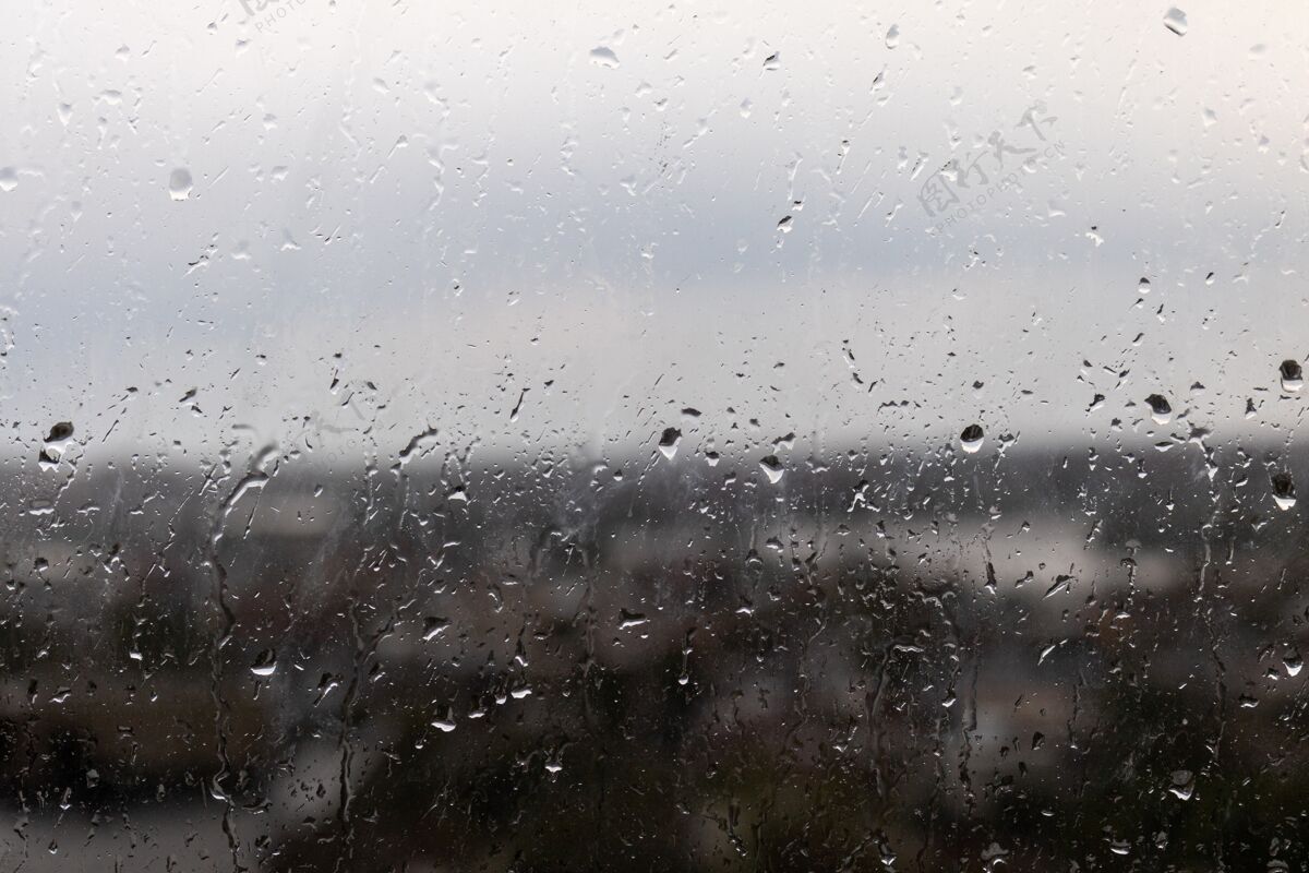 湿一个阴雨天窗户的特写镜头 雨点从窗户上滚下来季节水雨