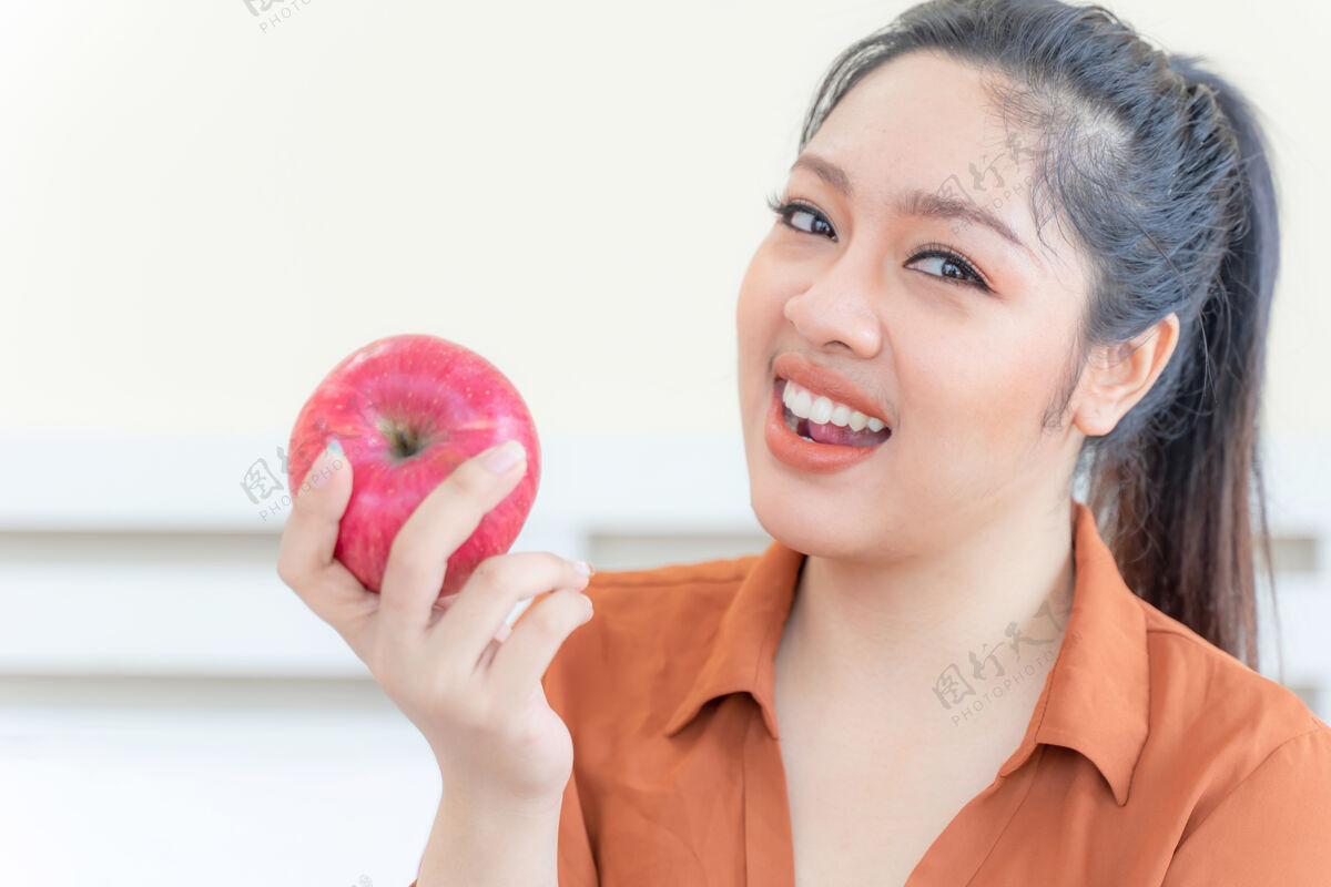 糖果超重的亚洲丰满女性与苹果腹部健康苹果