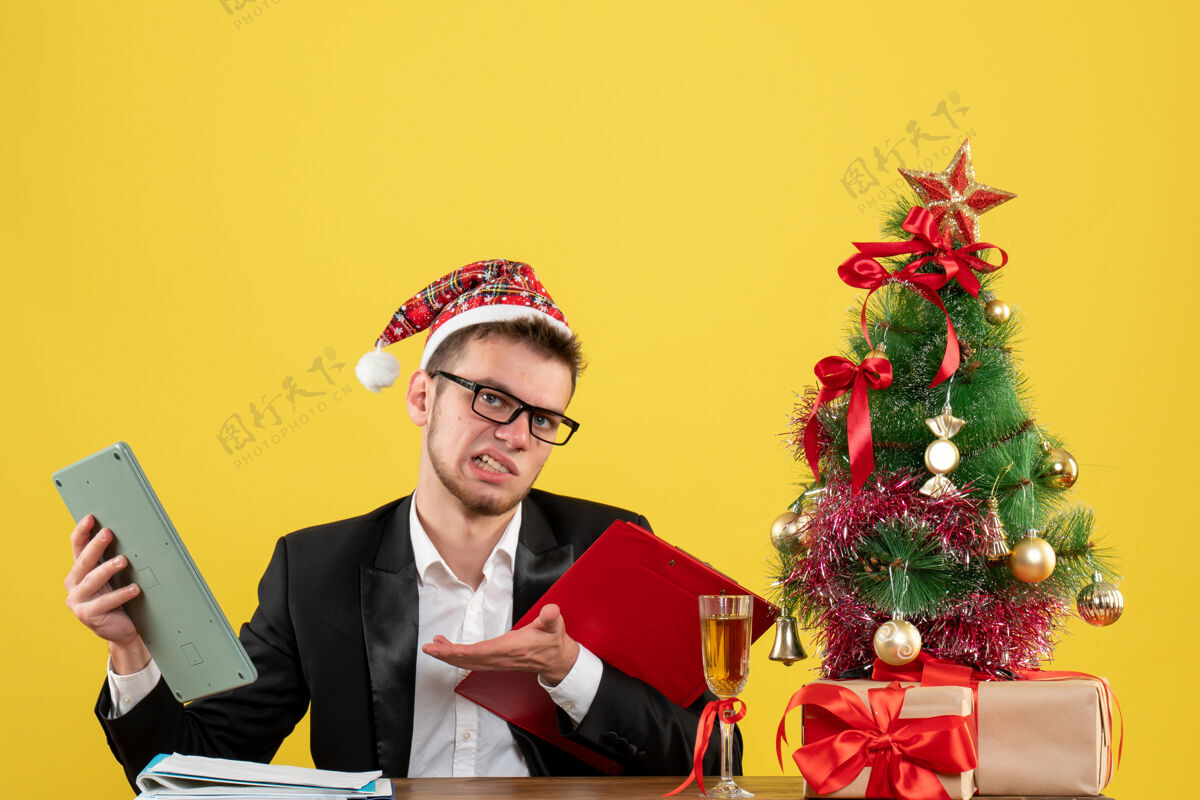 男工人正面图男性工人坐在黄色的笔记本和计算器上新郎圣诞节男