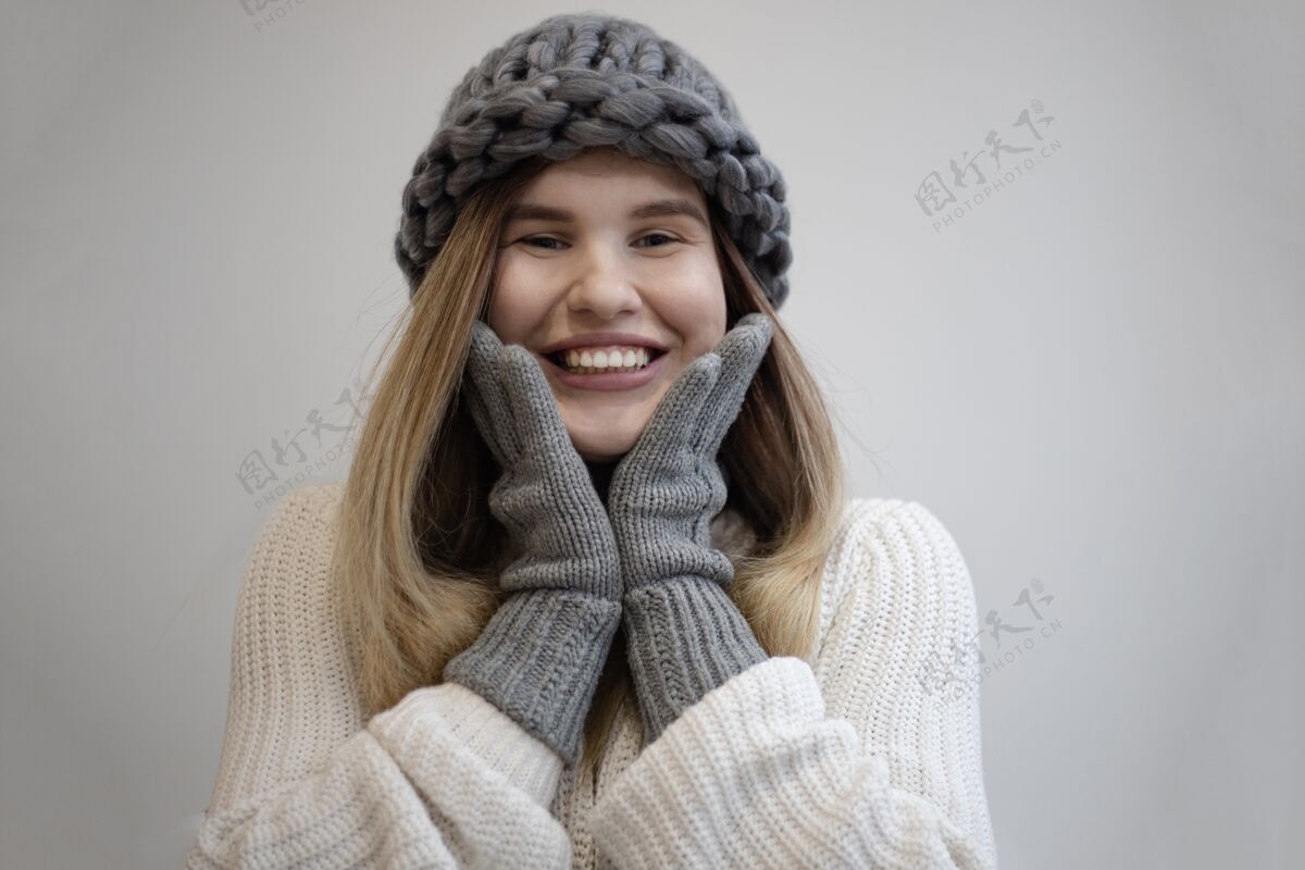 白种人美丽的镜头 一个美丽的开朗的女人戴着灰色针织帽子和手套快乐时尚漂亮