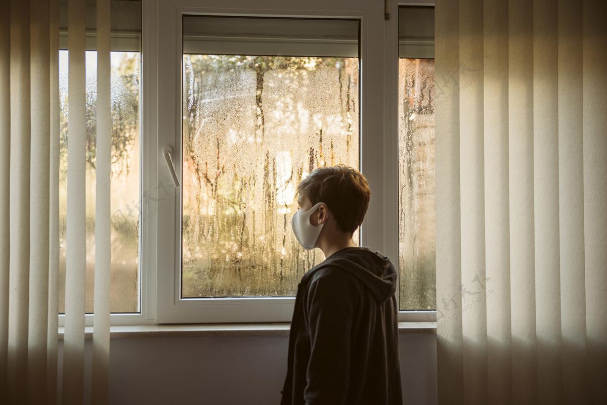Ncov戴着口罩的男孩站在窗户旁边疾病健康检疫