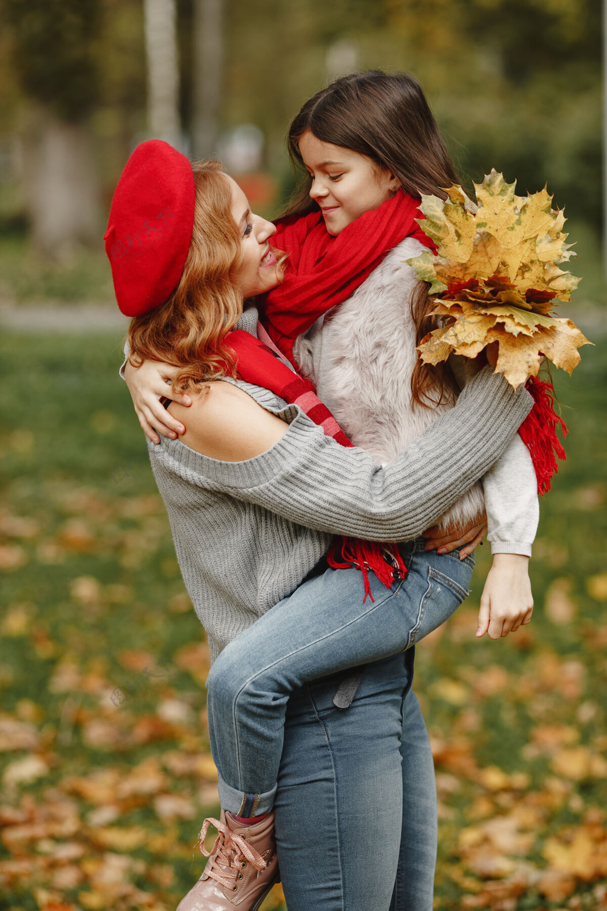 快乐时髦的母亲带着女儿黄色的秋天戴着红领巾的女人户外女儿快乐