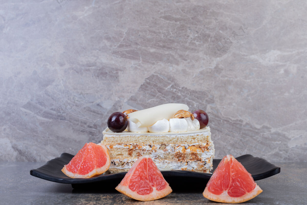 甜点在盘子里放一片白蛋糕和葡萄柚片甜食葡萄柚美味