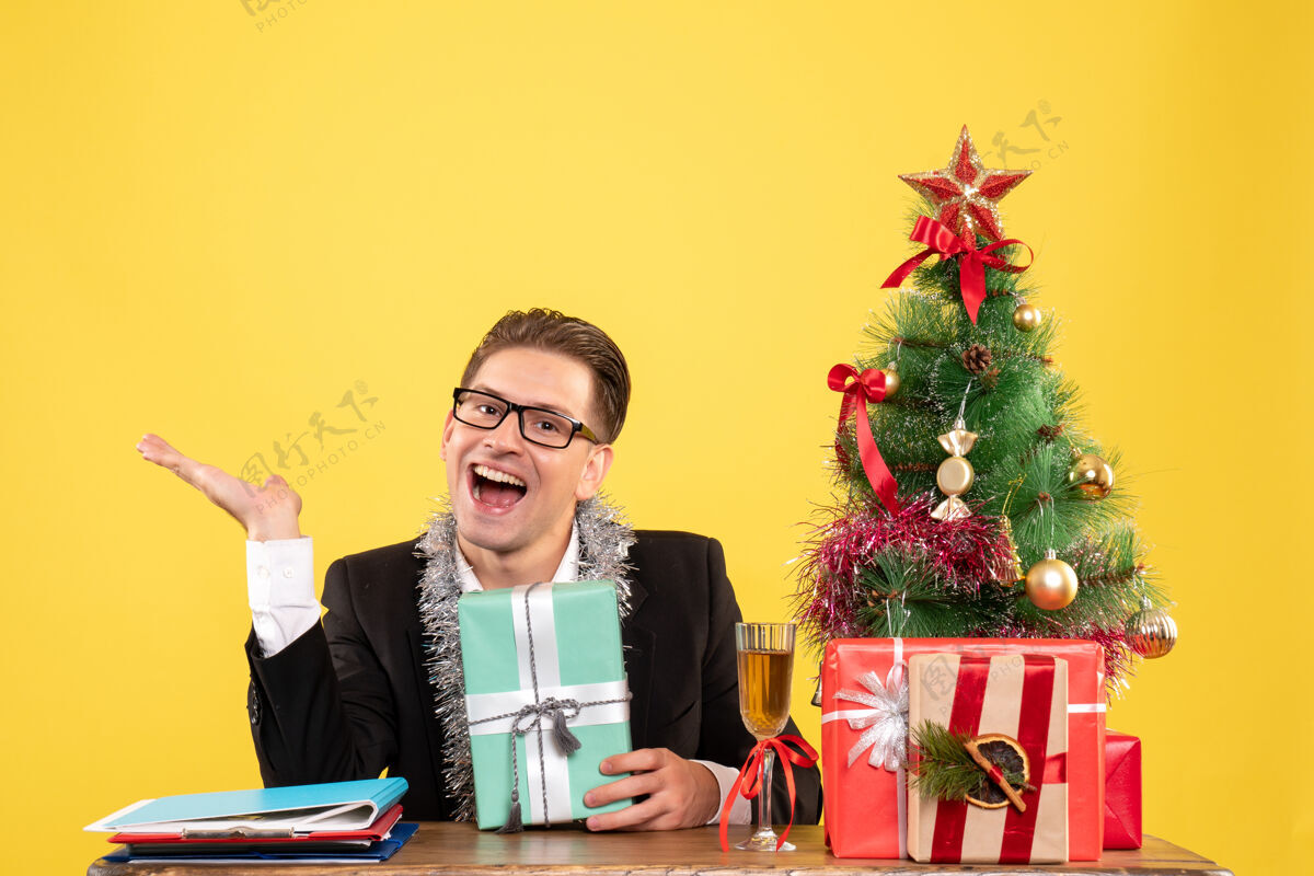 工作正面图：男工人拿着圣诞礼物和圣诞树坐着圣诞礼物年份