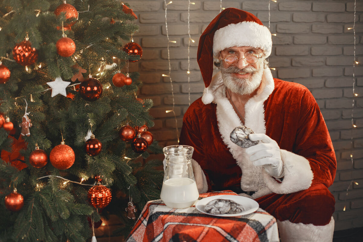 帽子圣诞老人在圣诞树旁休息家居装饰给圣诞老人的礼物家灯快乐的