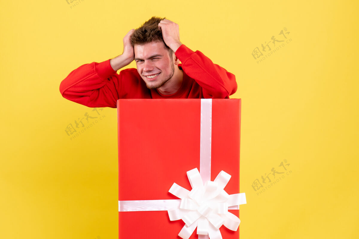 礼物正面图年轻男性站在礼品盒内雪丝带节日