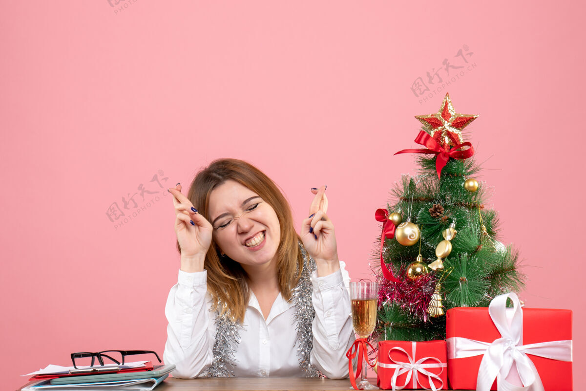 女工人女工人坐在桌子后面 手里拿着粉红色的礼物情感圣诞节希望