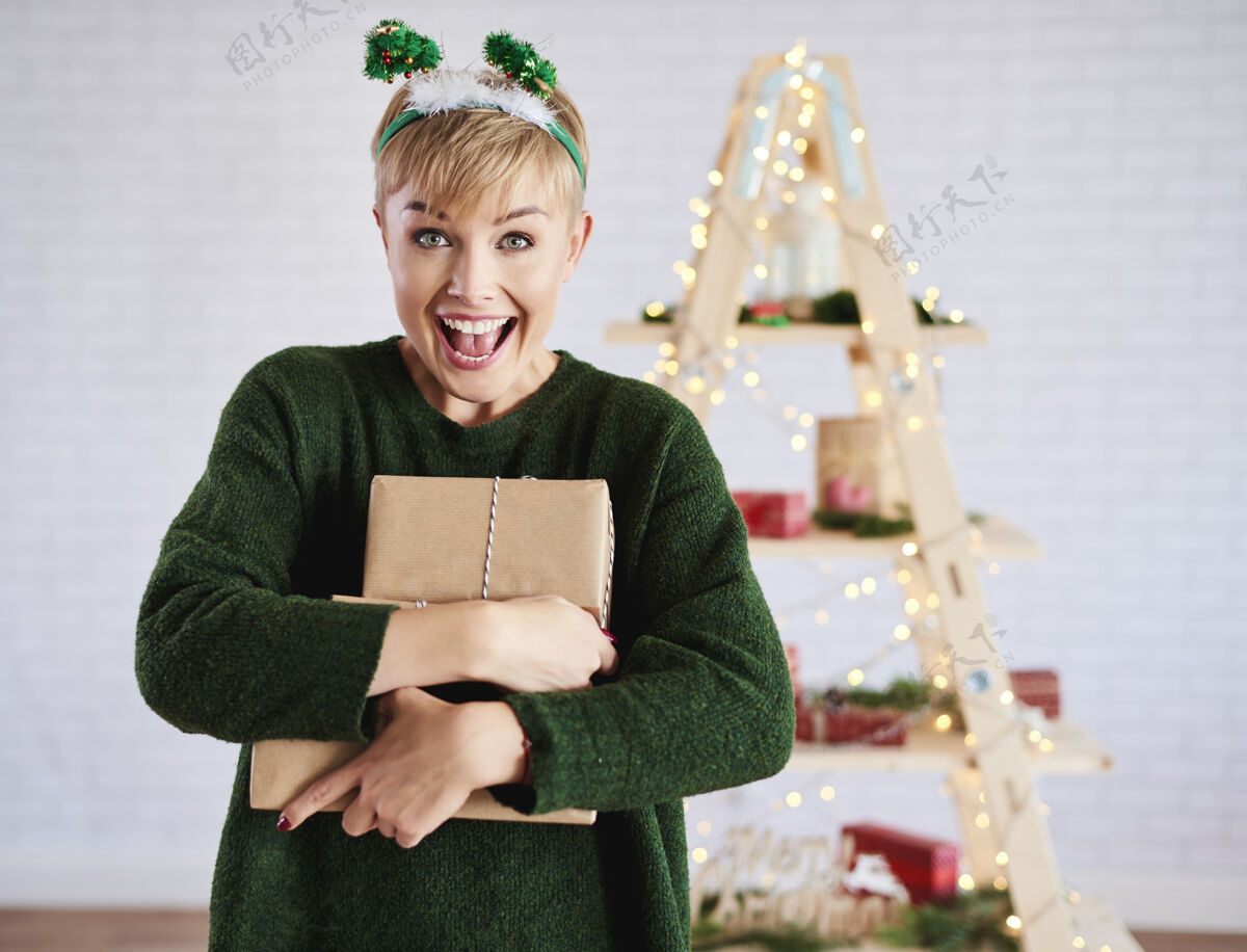 出售拿着圣诞礼物尖叫的女人收到嬉戏向上