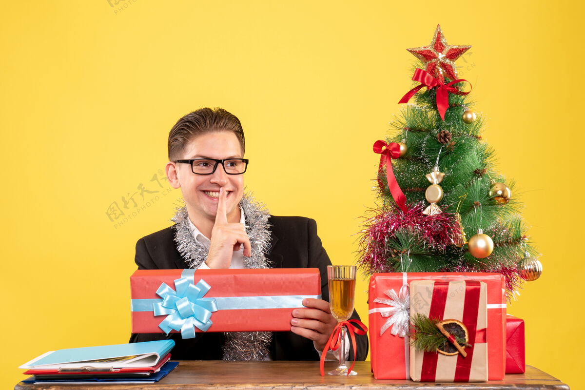 年份正面图男工人坐着拿着圣诞礼物微笑礼物工作