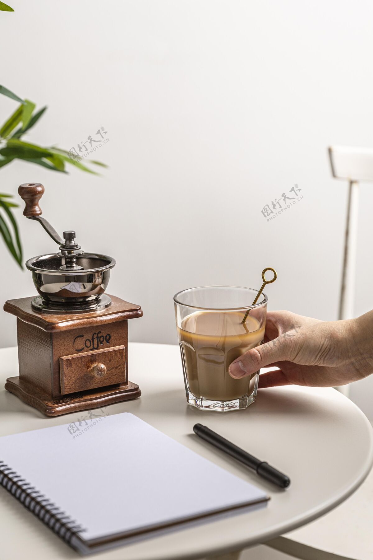 勺子高角度的咖啡杯与研磨机和笔记本放在桌上笔记本咖啡饮料