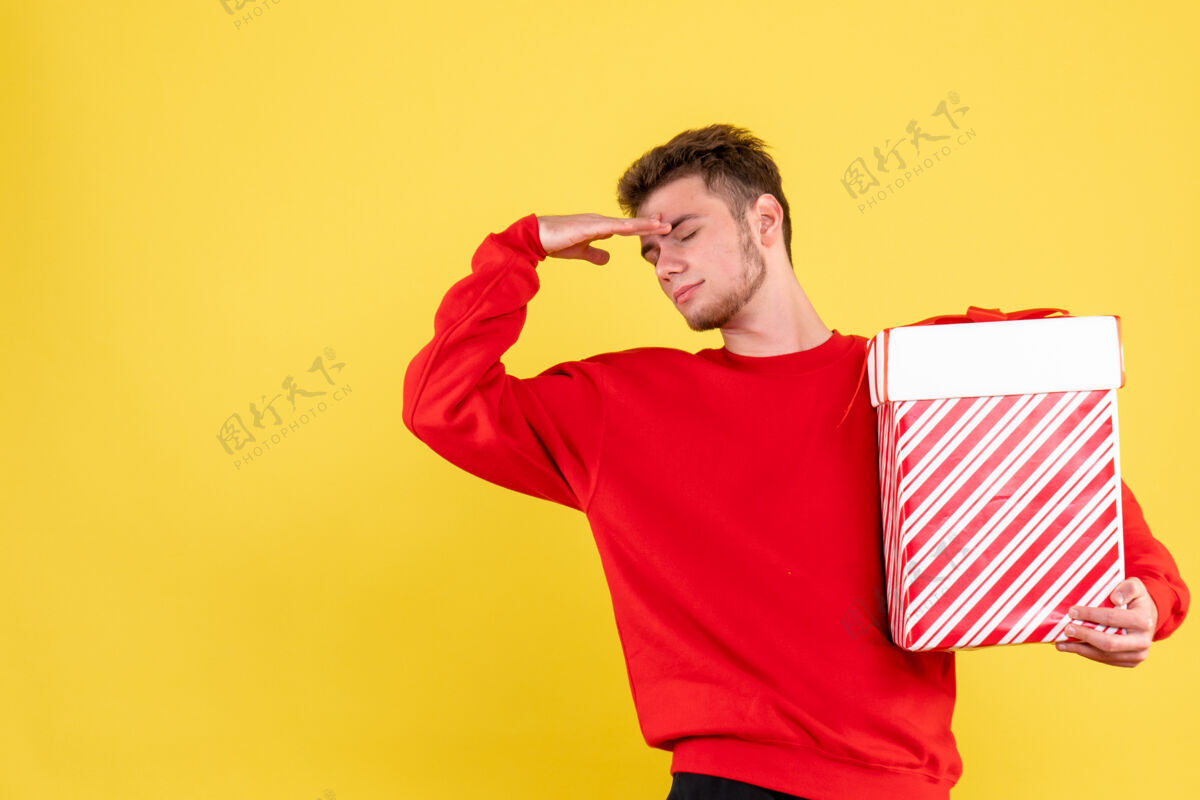 圣诞节正面图：穿着红色衬衫的年轻男性 带着圣诞礼物衬衫肖像成人