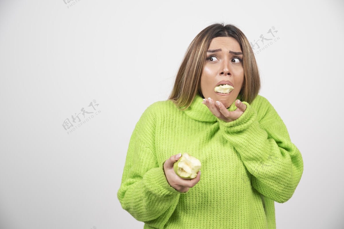 肖像穿着绿色t恤的年轻女子正在吃苹果美丽苹果表情