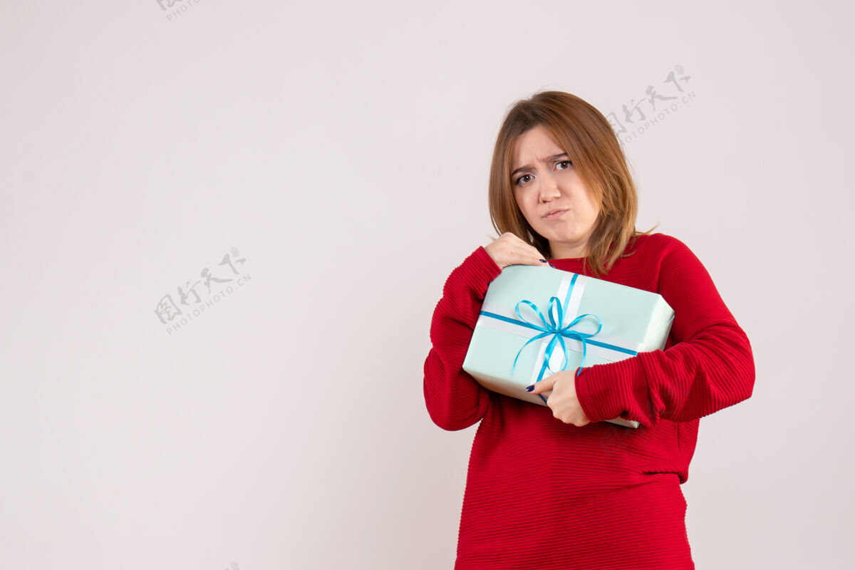 礼物前视图年轻女性站在圣诞礼物成人女性节日