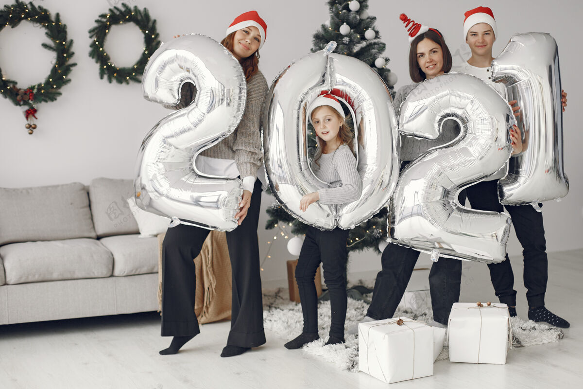 童年人们在为圣诞节做准备2021年拿着气球的人们\/一家人在节日的房间里休息孩子毛衣2021