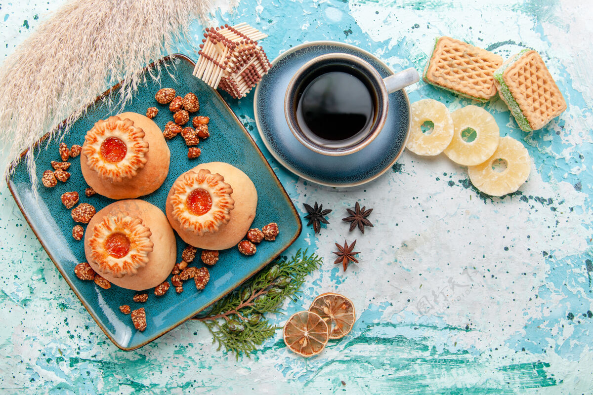 传统俯瞰美味饼干与干菠萝环华夫饼和咖啡在蓝色表面饼干饼干甜甜的糖的颜色华夫饼咖啡生的