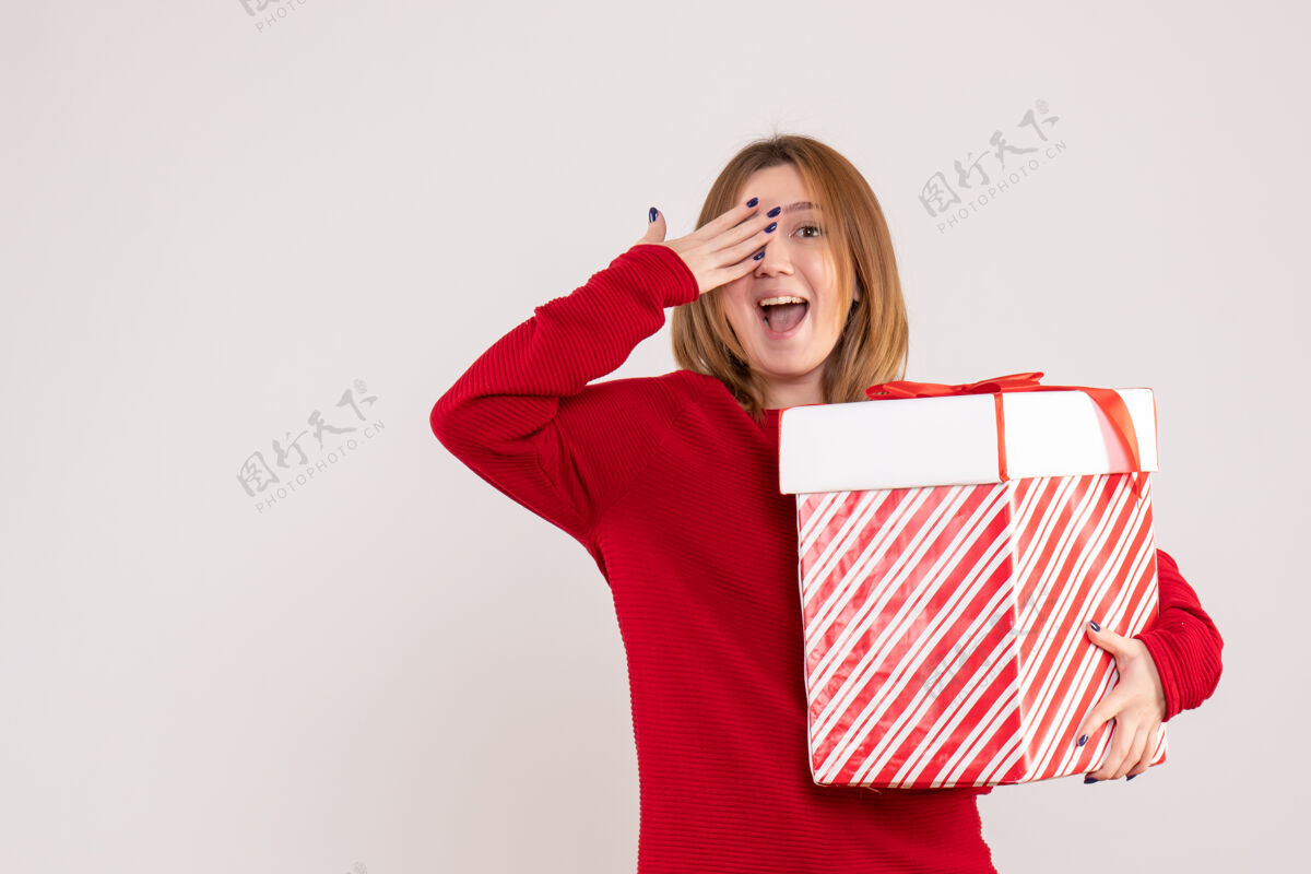 盒子正面图年轻女性手拿礼物盒站着微笑女人节日