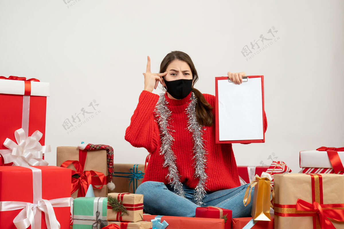 人穿着红色毛衣拿着文件的年轻女孩围坐在白色的礼物上礼物红色举行