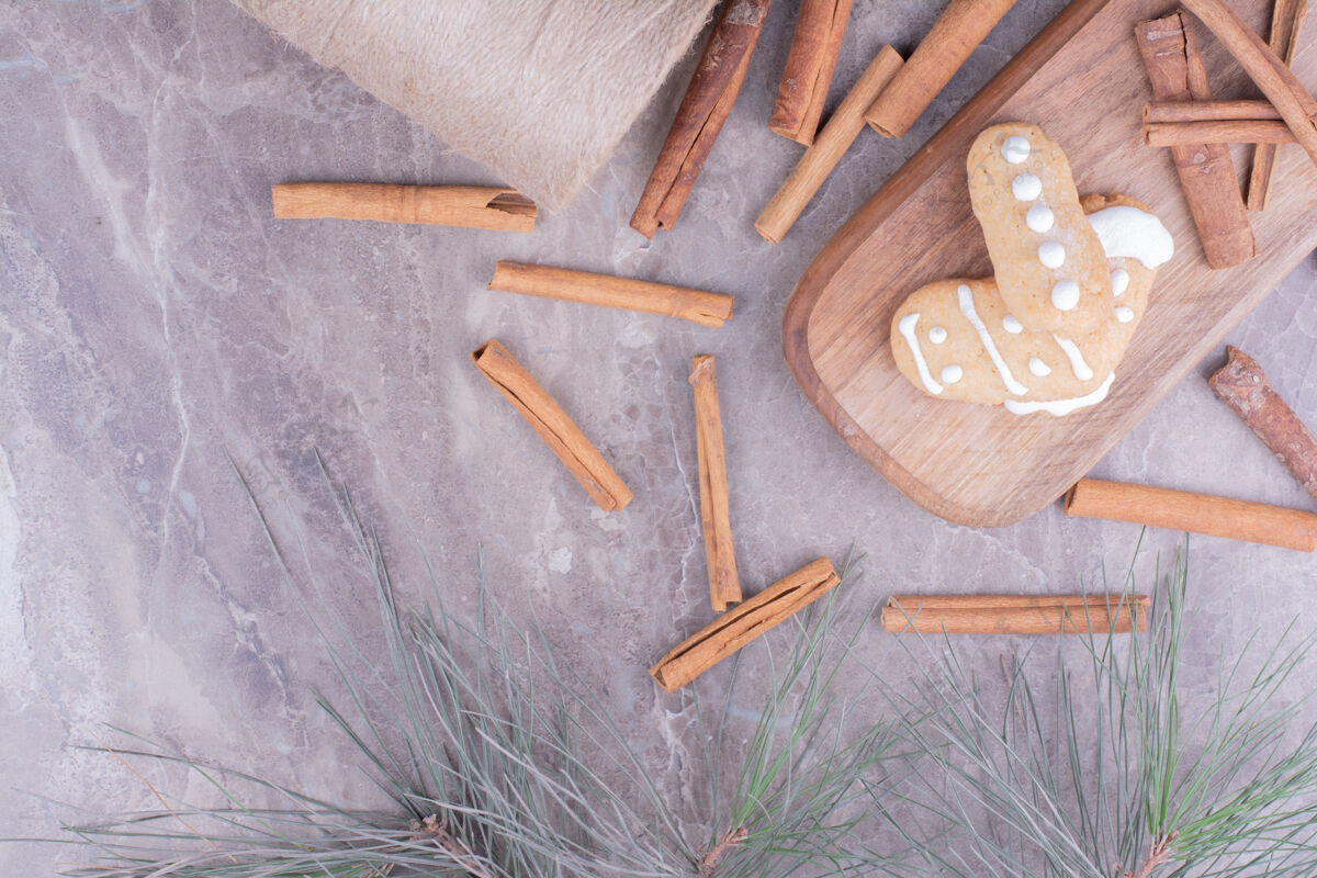 美味姜饼饼干和肉桂棒在长木板上咖啡馆扁平奶油