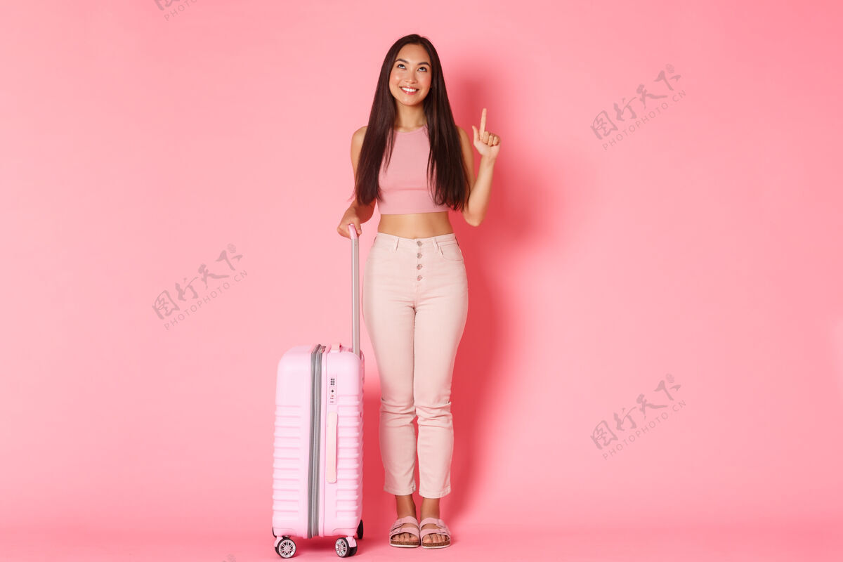 旅行社带着手提箱的年轻女子旅行者旅行包