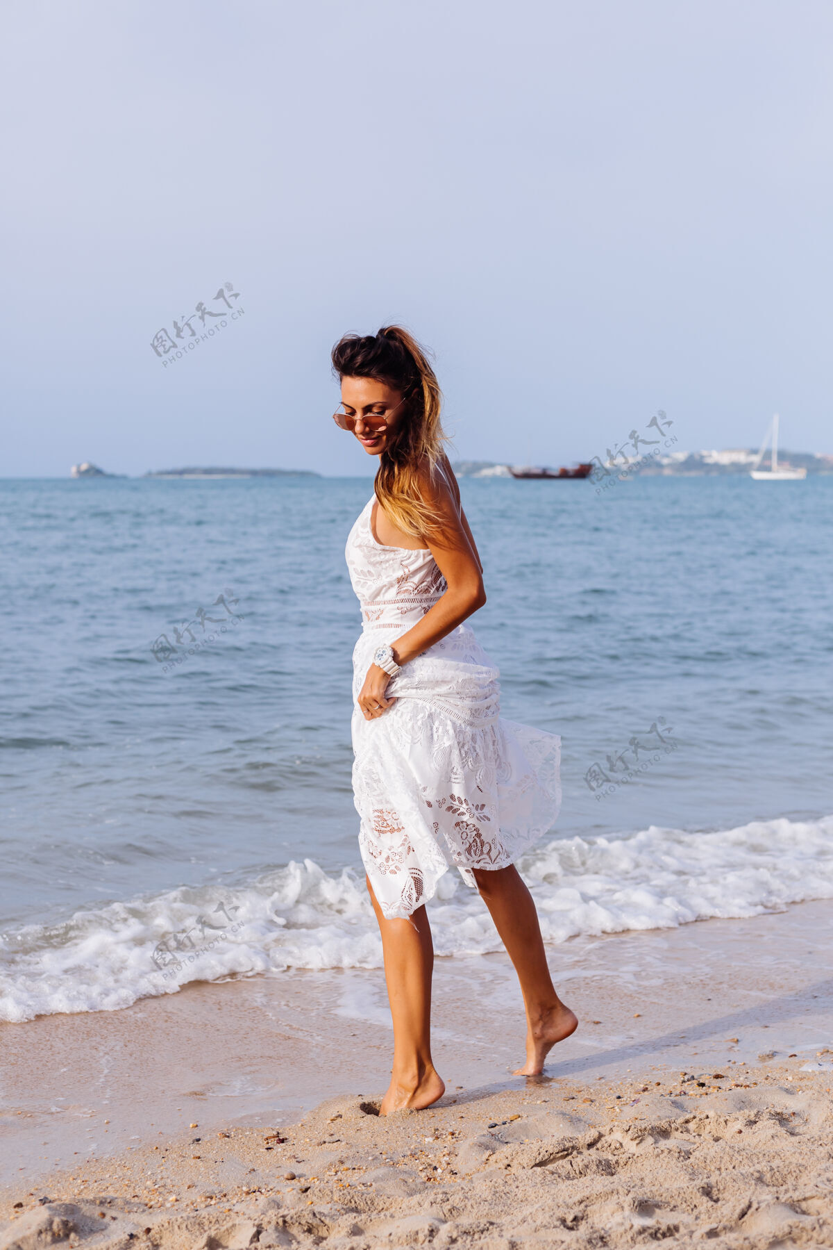 水日落时分 在热带海滩上 穿着白色夏装的晒黑女人的浪漫肖像女士女性服饰