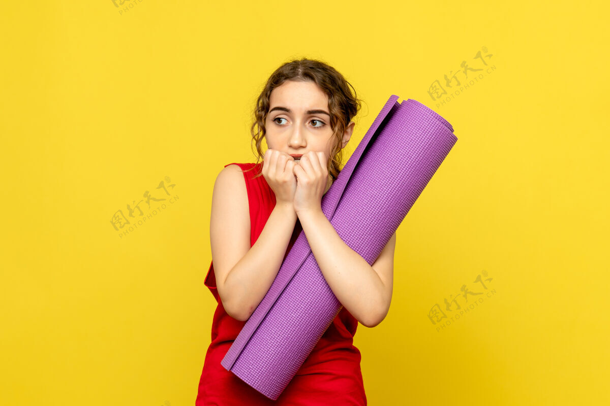 工作室黄墙上紫色地毯吓坏了年轻女子的正面图运动微笑模特
