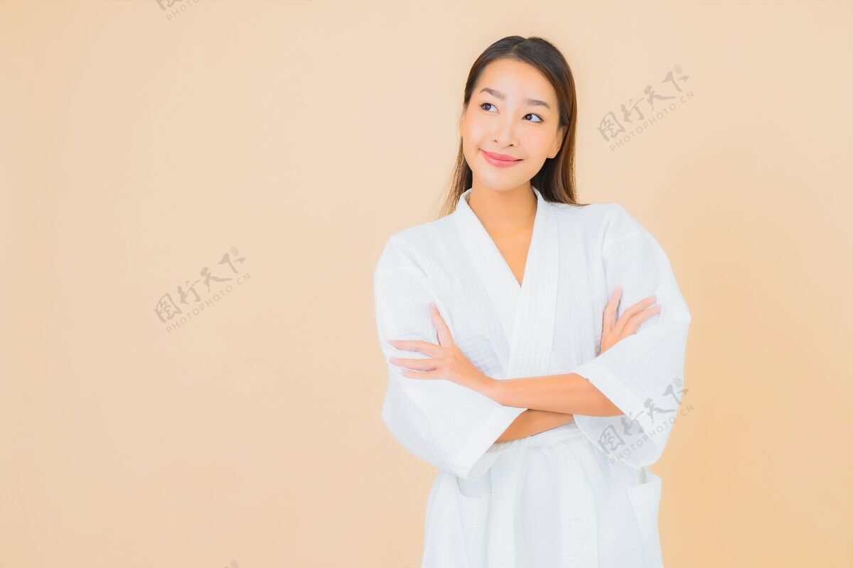 日本肖像美丽的亚洲年轻女子穿着米色的微笑浴袍成人清洁女士