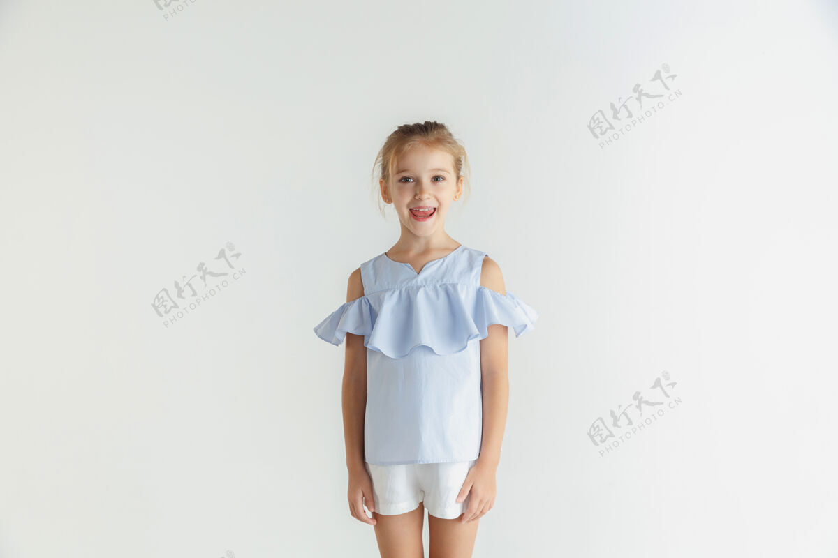 漂亮时尚的小女孩微笑着摆出休闲服装隔离在白色工作室教育自信金发