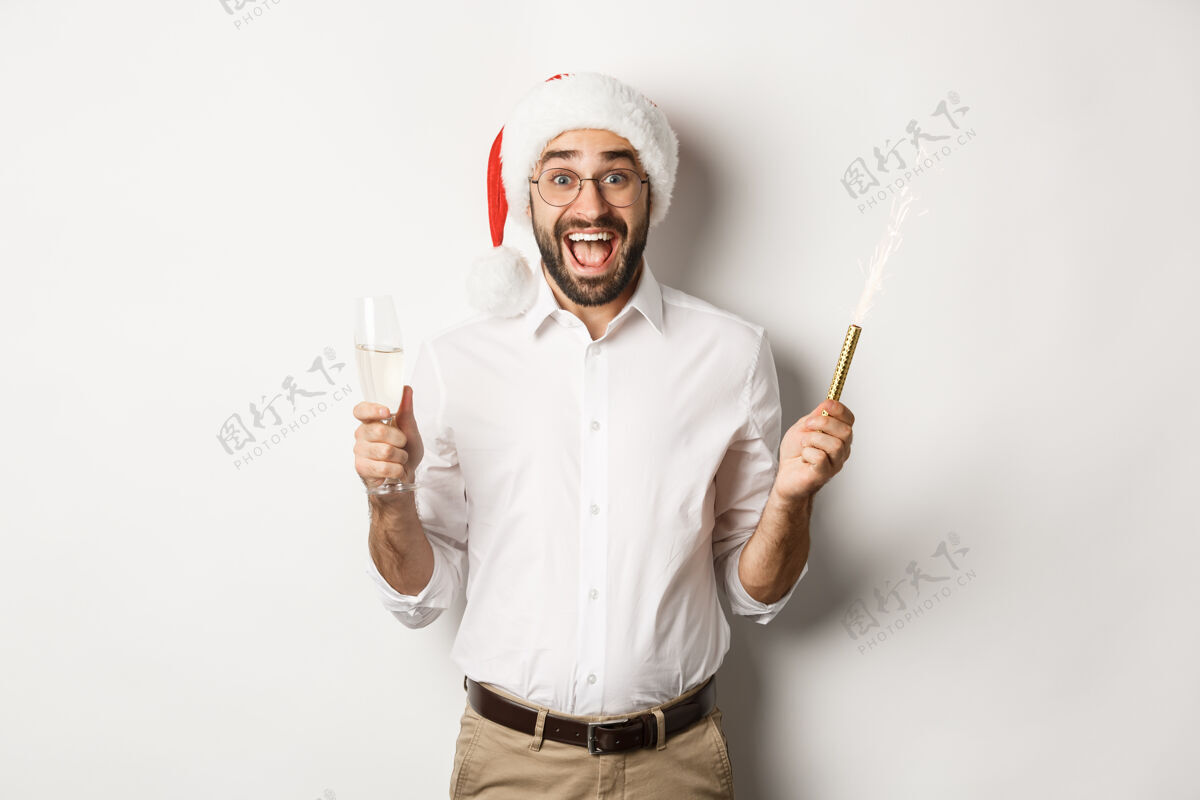 胡须寒假和庆祝活动戴着圣诞帽的快乐的家伙在新年派对上欢呼雀跃 喝着香槟 高喊着快乐快乐兴奋红色