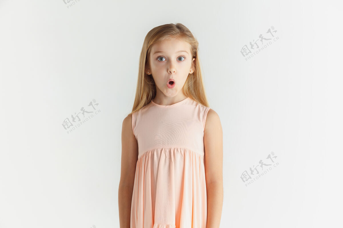 金发时尚的微笑小女孩在白色工作室里穿着隔离的裙子摆姿势孩子休闲表情