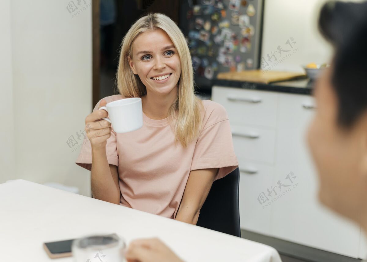 咖啡流感大流行期间 一个微笑的女人在家和她的男朋友喝咖啡Ncov男性杯子