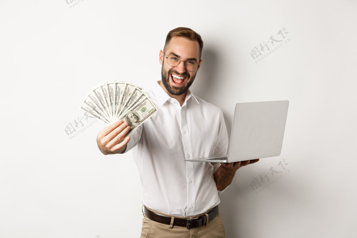富人商业和电子商务快乐的成功商人吹牛与金钱 工作在笔记本电脑在线 站着经理自信男人