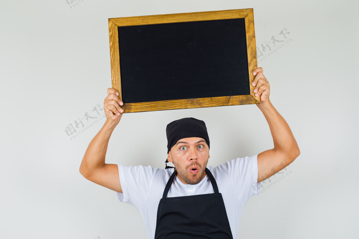 面包师面包师身穿t恤 围裙 头上举着黑板 看上去很惊讶工作肖像制服